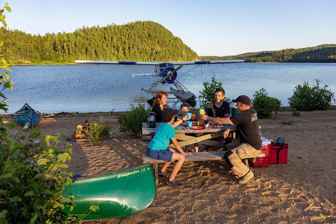 Canada, Province of Quebec, Mauricie Region, Hydravion Aventure, Saint-Maurice Wildlife Sanctuary north of Mauricie National Park, family camping for the night on a sandy beach on Lac Soucis with the pilot , dinner, aperitif MODEL RELEASE OK