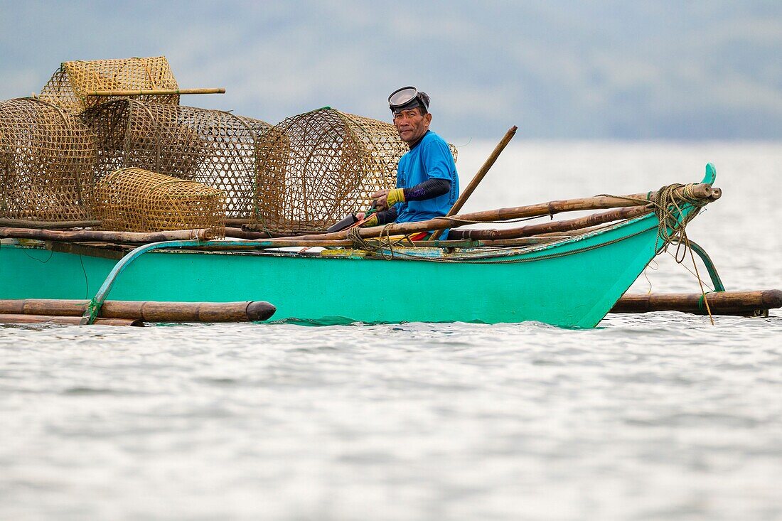 Philippines, Palawan, Malampaya Sound Protected Landscape and Seascape, fisherman dropping crab traps