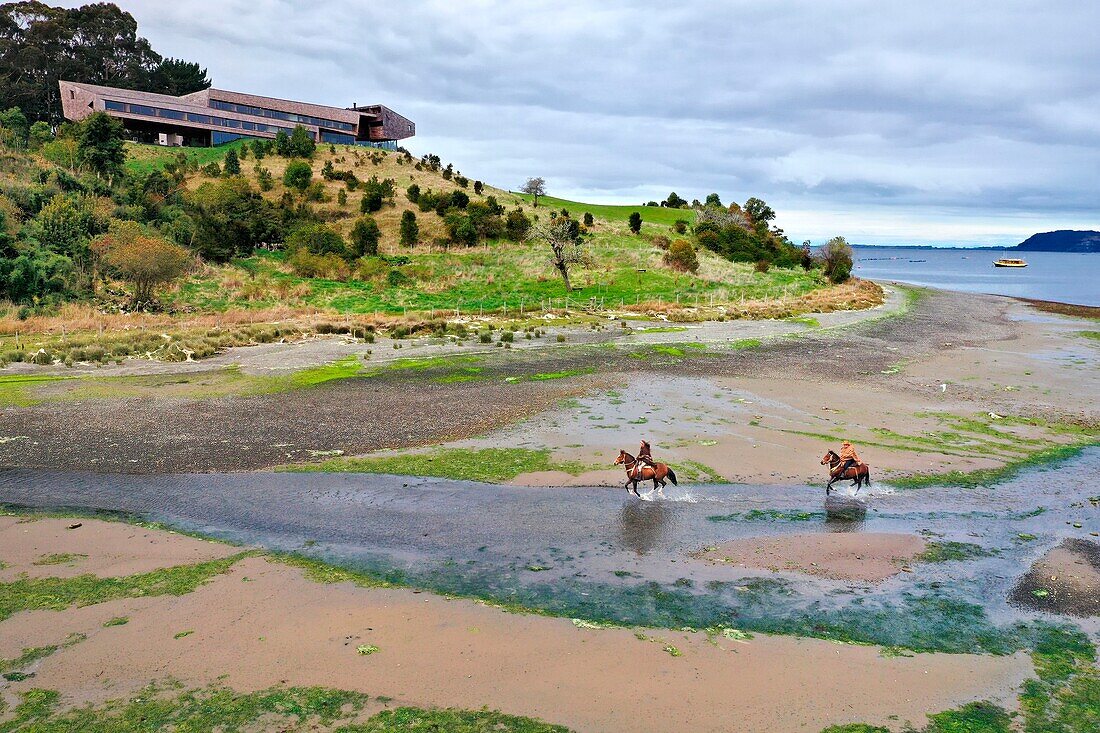 Chile, Los Lagos region, Chiloé Island, Castro District, Rilan Peninsula, San José Municipality, Tierra Chiloé hotel and riders in the estuary (aerial view)