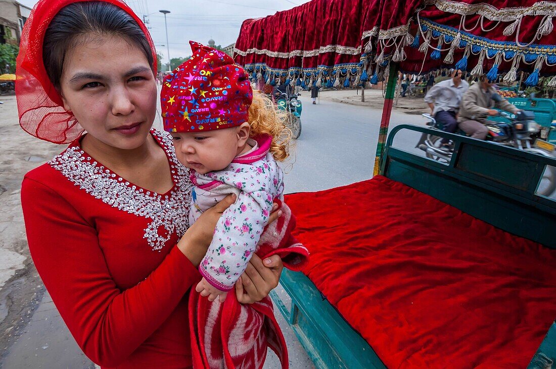 China, Xinjiang autonomous region, Yarkand, woman and baby wearing a blond wig