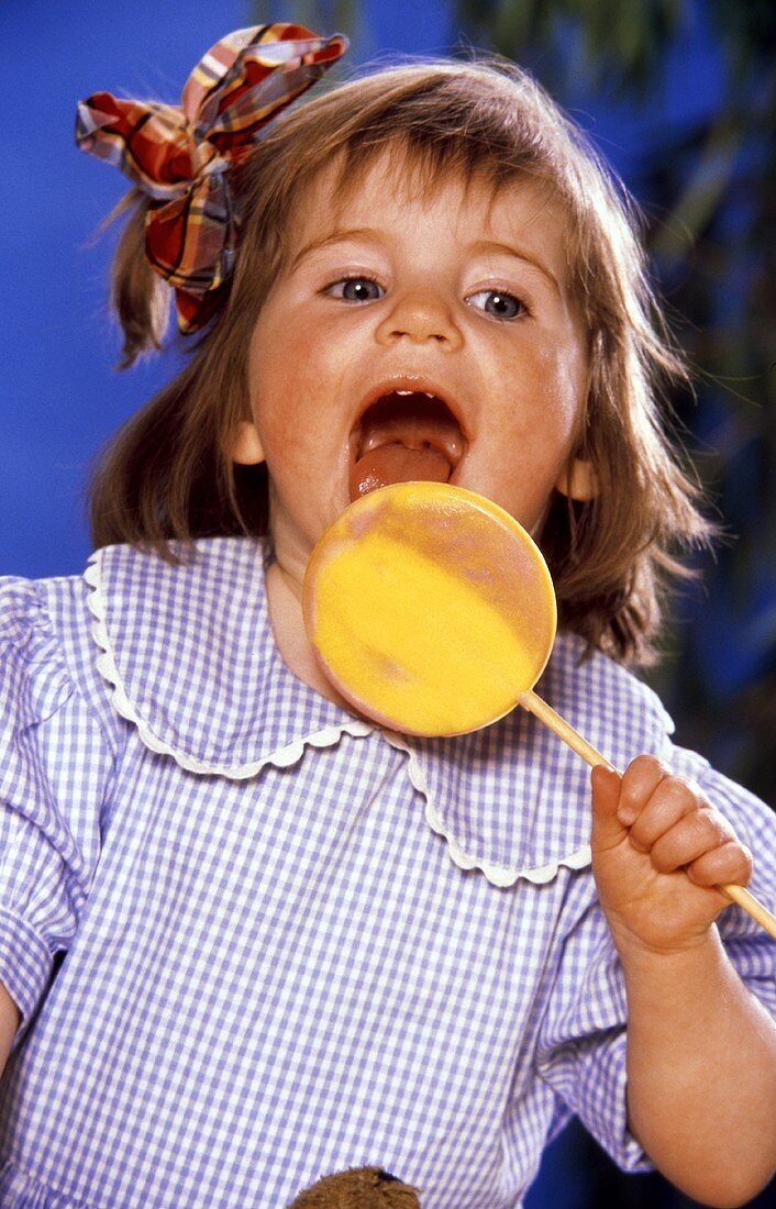 Young Child Licking a Lollipop