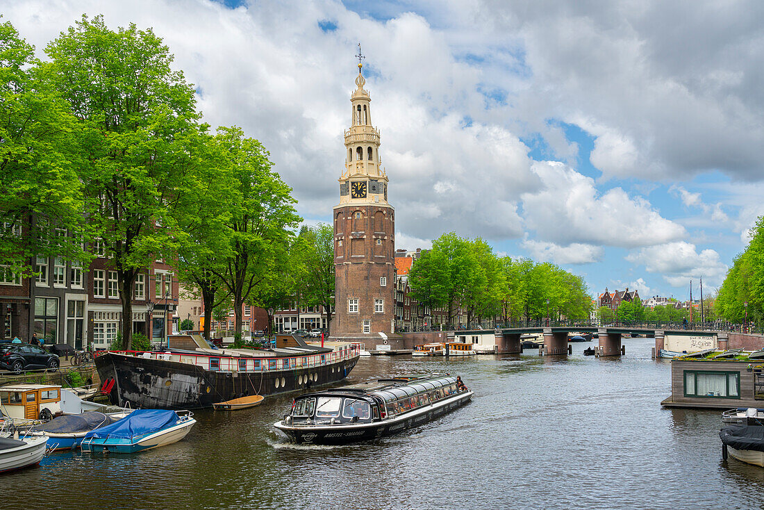 Boat on Rapenburgwal canal and Montelbaanstoren tower in the background, Amsterdam, The Netherlands, Europe