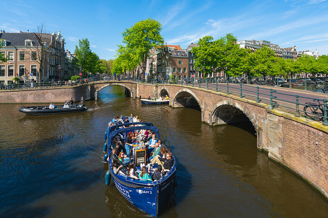 Tourist boats at intersection of Keizersgracht and Reguliersgracht canals, Amsterdam, The Netherlands, Europe