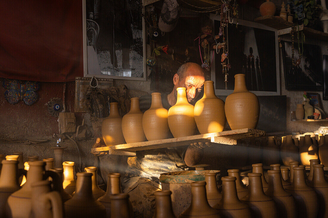 Meister bei der Arbeit in einer Töpferwerkstatt voller Vasen,Avanos,Kappadokien,Region Zentralanatolien,Anatolien,Türkei,Kleinasien,Asien