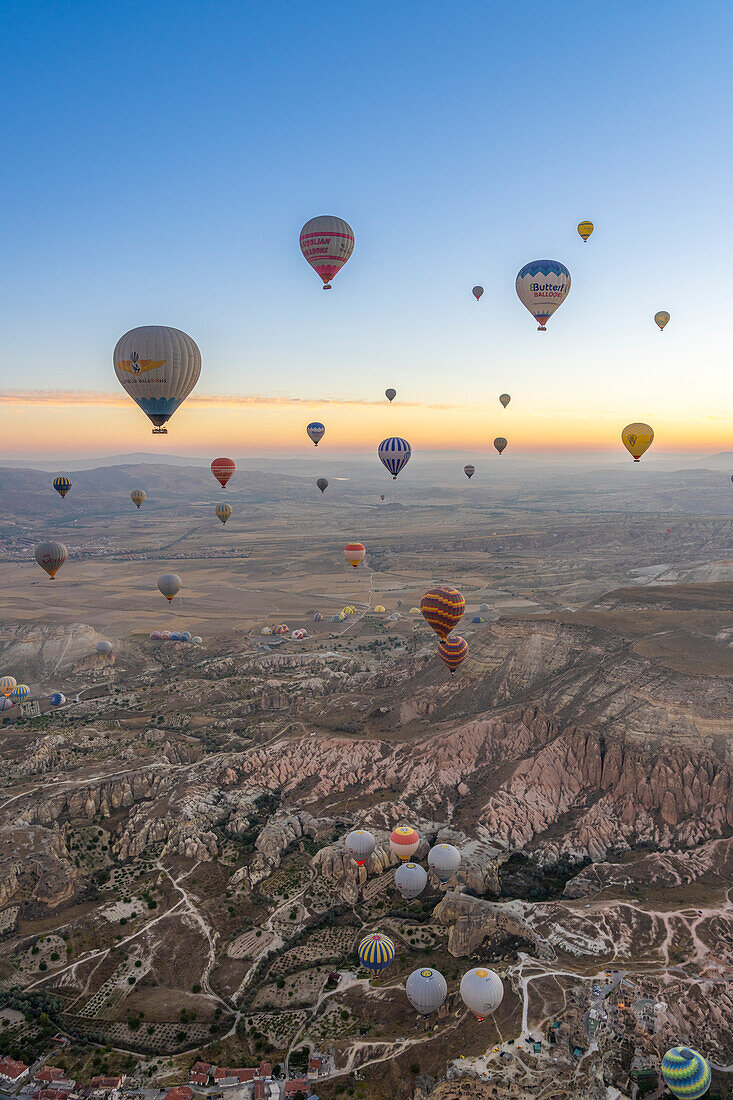 Luftaufnahme von Cavusin und Heißluftballons in der Morgendämmerung,Bezirk Avanos,Provinz Nevsehir,Kappadokien,Region Zentralanatolien,Anatolien,Türkei,Kleinasien,Asien