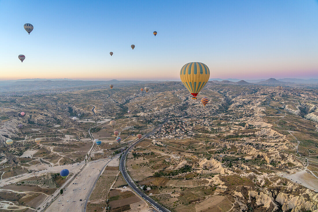 Luftaufnahme von Cavusin und Heißluftballons im Morgengrauen,Bezirk Avanos,Provinz Nevsehir,Kappadokien,Region Zentralanatolien,Anatolien,Türkei,Kleinasien,Asien