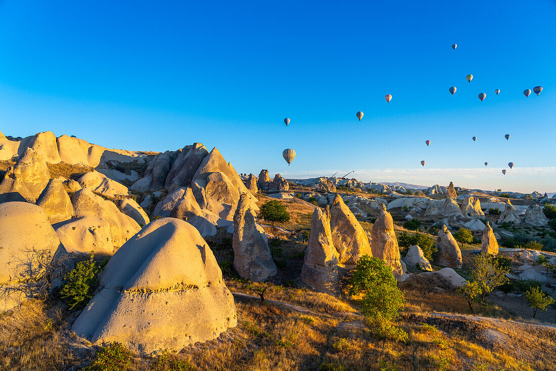 Aerial view of hot air balloons over rock formations at sunrise, Goreme, Goreme Historical National Park, UNESCO World Heritage Site, Cappadocia, Central Anatolia Region, Anatolia, Turkey, Asia Minor, Asia