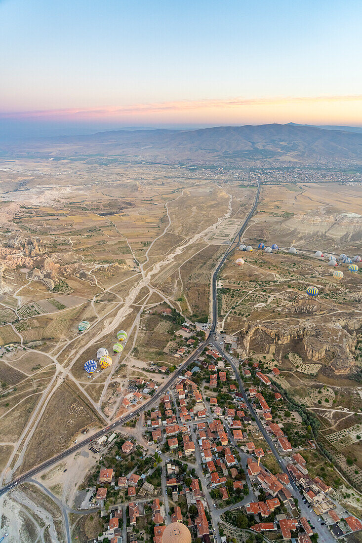 Luftaufnahme von Cavusin und Heißluftballons im Morgengrauen,Bezirk Avanos,Provinz Nevsehir,Kappadokien,Region Zentralanatolien,Anatolien,Türkei,Kleinasien,Asien