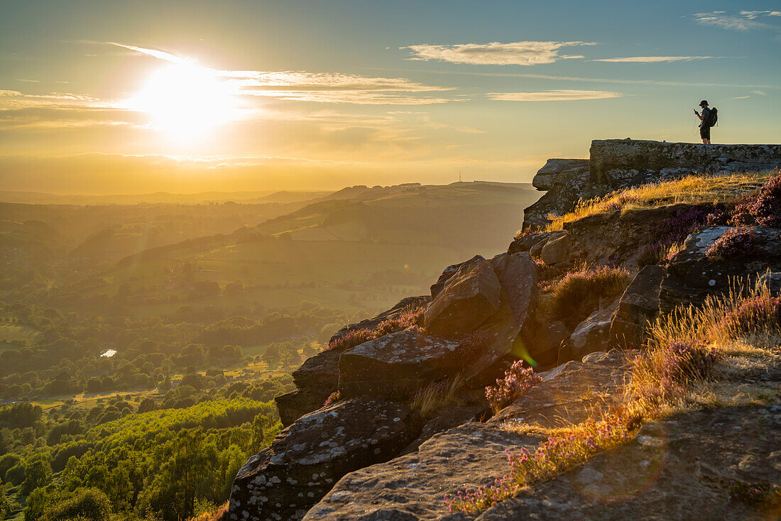 Blick eines Wanderers auf die Landschaft von Curbar Edge bei Sonnenuntergang,Peak District National Park,Baslow,Derbyshire,England,Vereinigtes Königreich,Europa