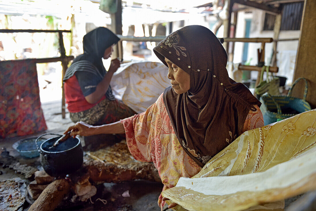 Women using a pen-like tool (canting)  to apply liquid hot wax to create pattern on the fabric without preliminary drawing, Nyah Kiok batik house, craft production by seven women for over 30 years, Lasem, Java island, Indonesia, Southeast