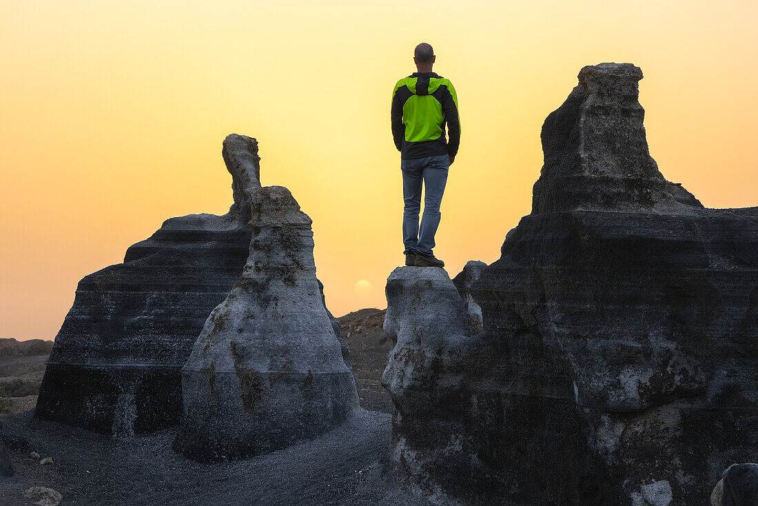 A tourist observes sunset at Stratified city in Lanzarote, Teseguite, Las Palmas, Lanzarote, Canary Islands, Spain, Atlantic, Europe