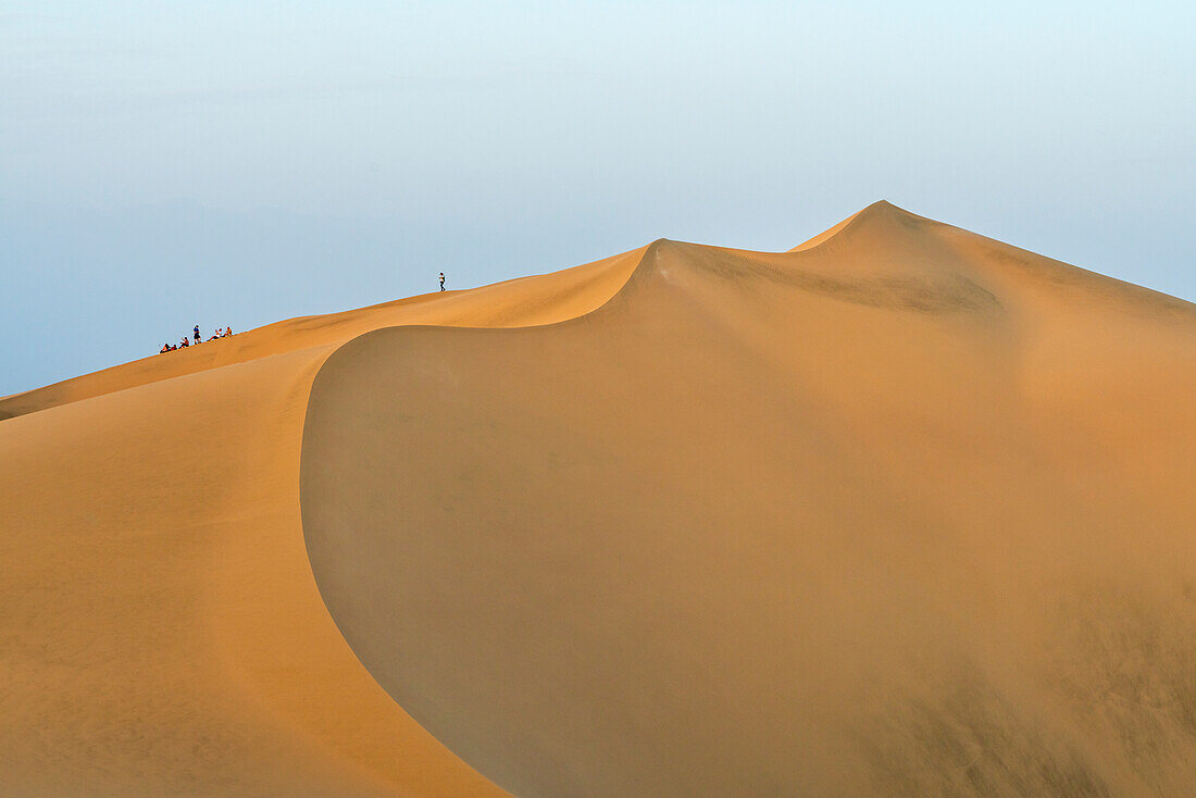 Touristen beobachten den Sonnenuntergang von einer Sanddüne in der Wüste,Huacachina,Bezirk Ica,Provinz Ica,Region Ica,Peru,Südamerika