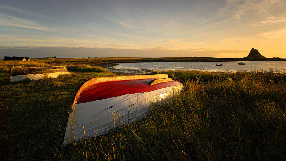 Boats on the shore of Holy Island with Lindisfarne Castle in the background, Northumberland, England, United Kingdom, Europe