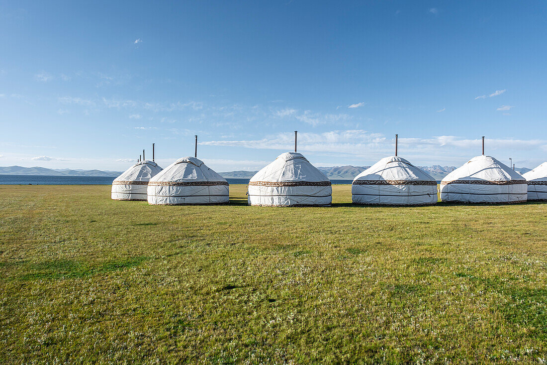 Traditional yurts dotting the picturesque landscapes near Song-Kol Lake in bright daylight, Kyrgyzstan, Central Asia, Asia