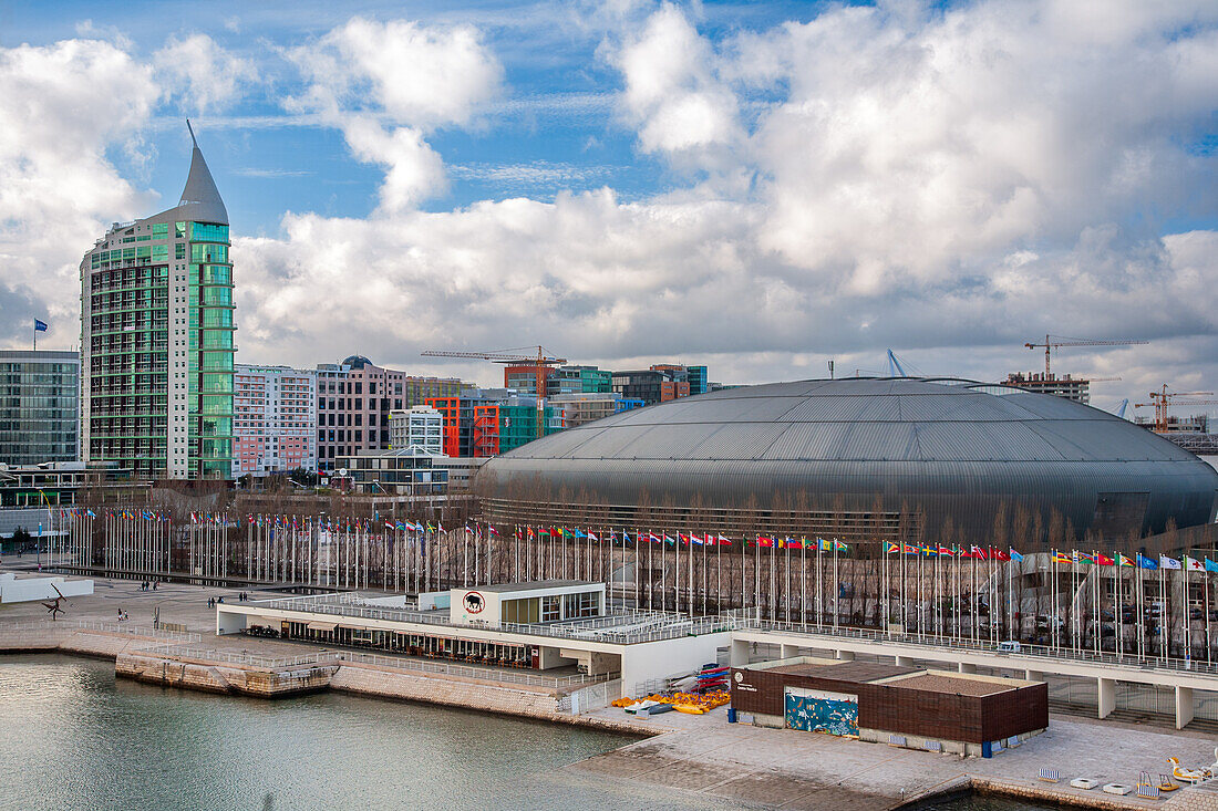 Eine atemberaubende Aufnahme des Parque das Nacoes mit der ikonischen MEO Arena in Lissabon,Portugal. Das Gebiet ist geprägt von moderner Architektur und leuchtenden Farben und bietet ein lebendiges Stadtbild.