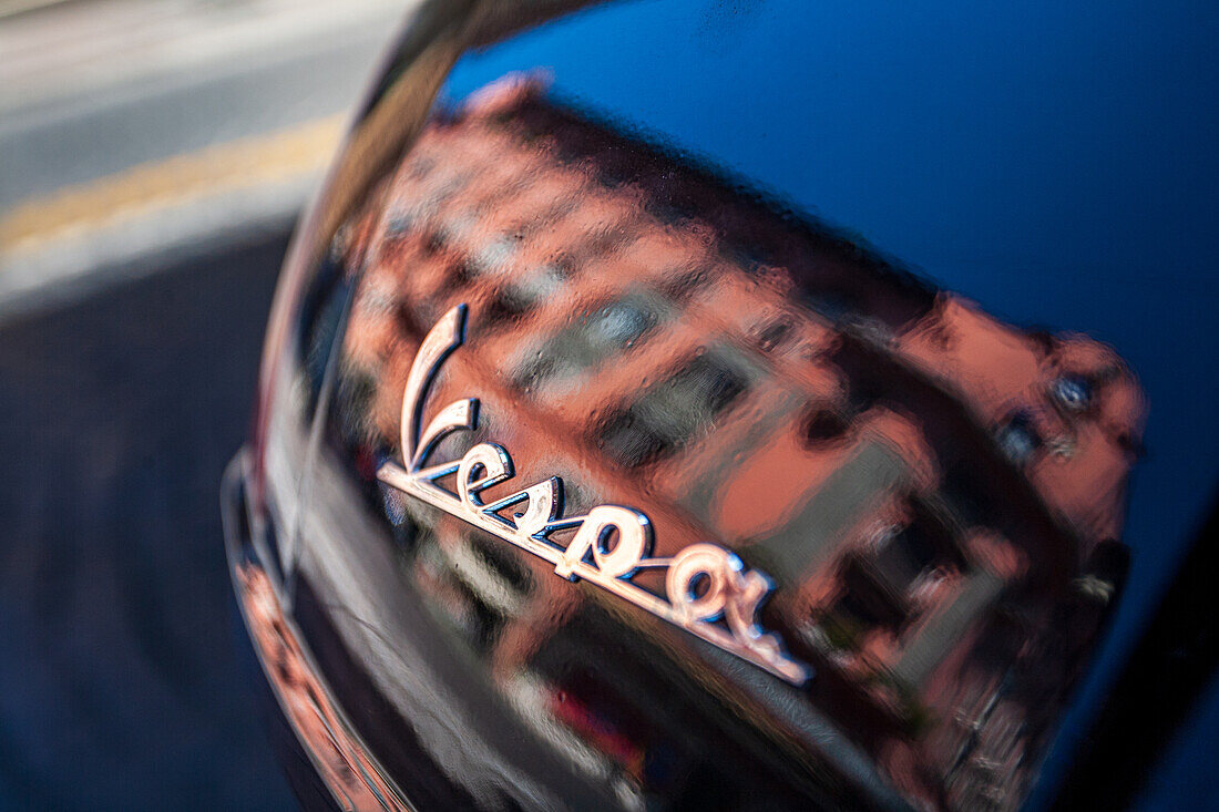 Rome, Italy, July 22 2017, A Roman house beautifully reflects on the surface of a parked Vespa scooter in the streets of Rome.