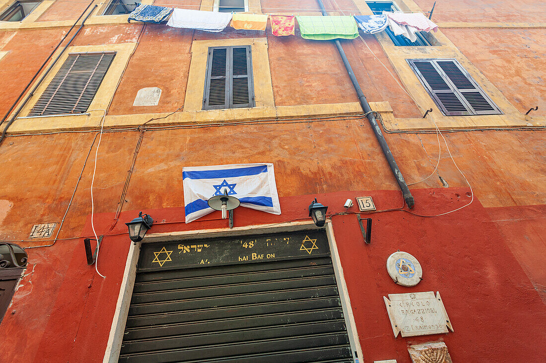 Rome, Italy, July 2017, The vibrant Jewish flag hangs prominently in the Roman ghetto, showcasing cultural heritage in a historic setting.