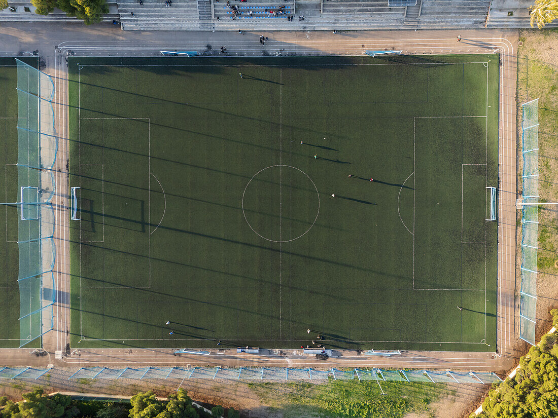 Luftaufnahme eines Amateurfußballspiels bei Sonnenuntergang