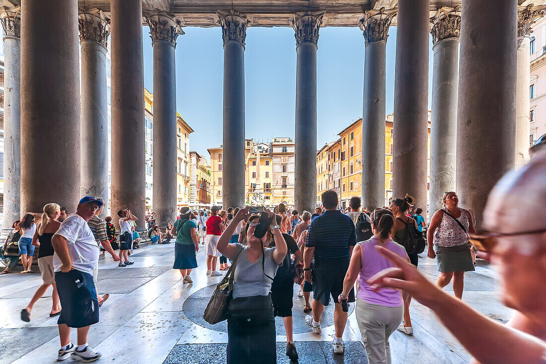 Rome, Italy, July 2017, A lively scene of tourists exploring the iconic Pantheon entrance, with the vibrant Piazza della Rotonda visible in the background, showcasing Rome’s rich architectural heritage and cultural attractions.