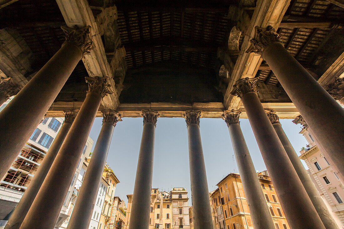 The majestic columns of the Pantheon frame the charming buildings of Rotonda square in the heart of Rome, Italy.