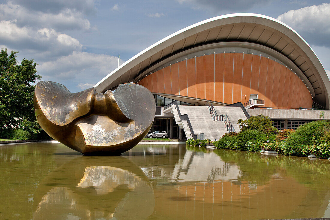 Das ikonische Haus der Kulturen der Welt mit seiner beeindruckenden Architektur und einem ruhigen Teich,umgeben von üppigem Grün,in Berlin,Deutschland.