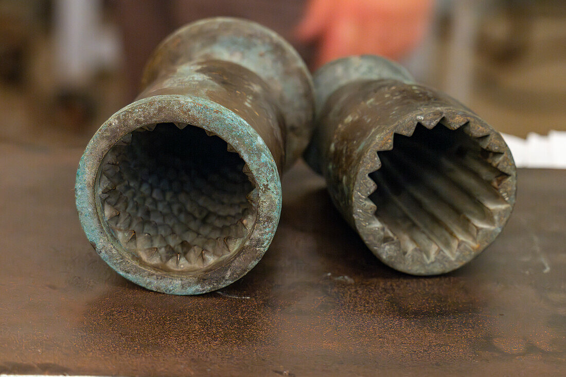 Metal molds for creating surface shapes in a molten glass gather in a glass studio in Venice, Italy.