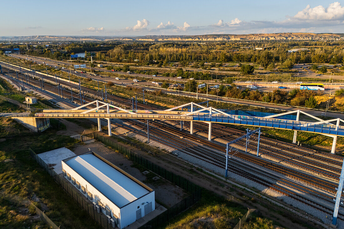 Luftaufnahme einer Brücke über die Bahngleise bei Sonnenuntergang