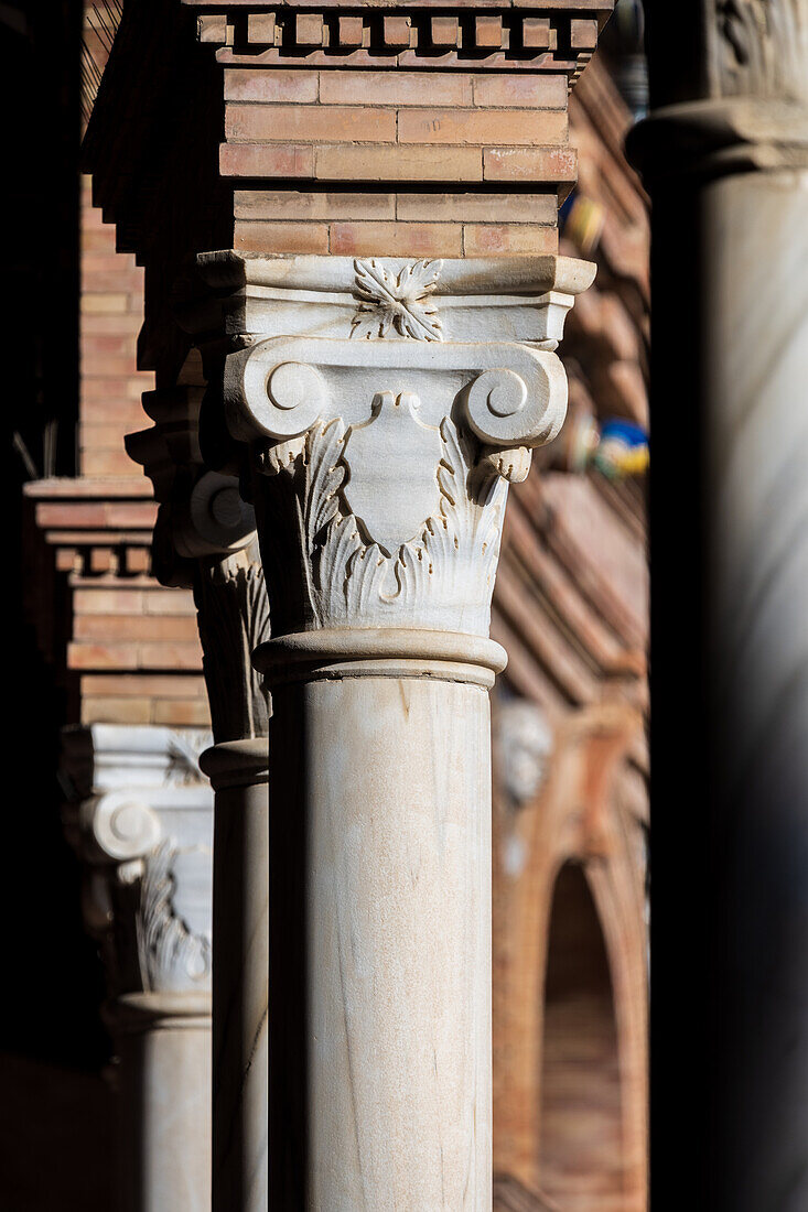 Nahaufnahme von verschnörkelten Säulen mit komplizierten Details auf der beeindruckenden Plaza de España in Sevilla,Spanien,die die Eleganz und Handwerkskunst der spanischen Architektur hervorheben.