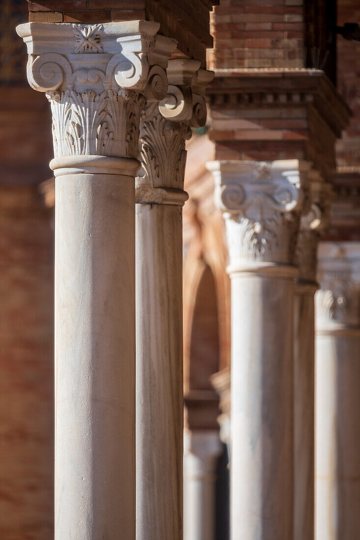 Nahaufnahme von verzierten Säulen mit komplizierten Details auf der beeindruckenden Plaza de España in Sevilla,Spanien,die die Eleganz und Handwerkskunst der spanischen Architektur unterstreicht.