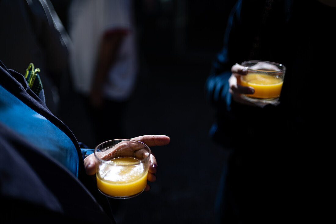 Close up of guests enjoying mimosa cocktails at a wedding party in Malaga, Spain. Celebratory atmosphere and stylish gathering in a beautiful location.