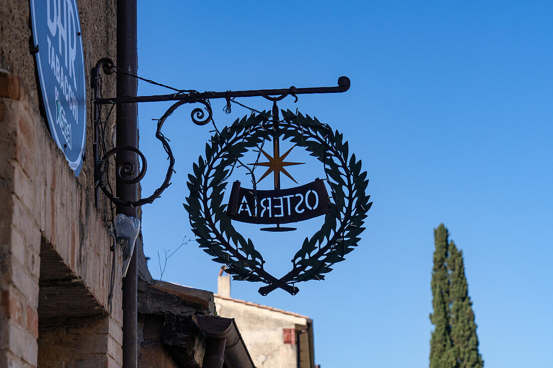 A metal sign on a traditional building in the borga or medieval hilltop town of Farfa, Italy.