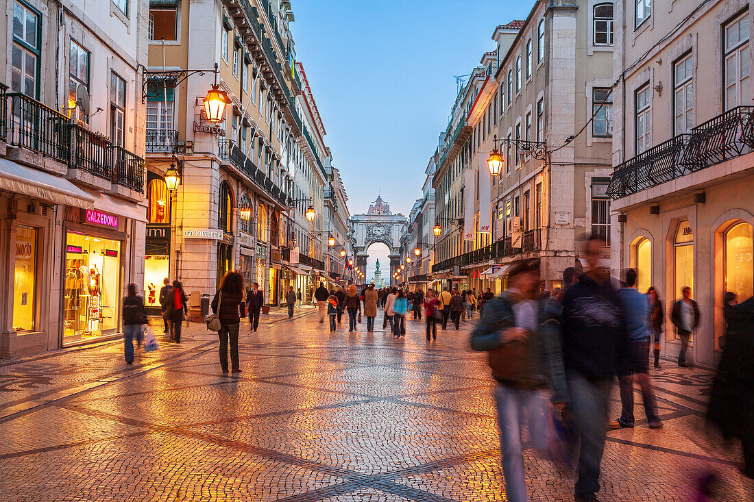 Lisbon, Portugal, March 1 2007, Pedestrians enjoy a leisurely walk along Augusta Street as dusk falls over Lisbon's bustling Baixa district, filled with charming shops.