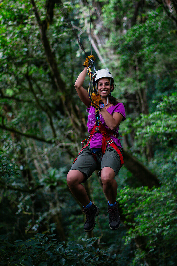 Young caucasian woman having fun during a Canopy tour in Costa Rica