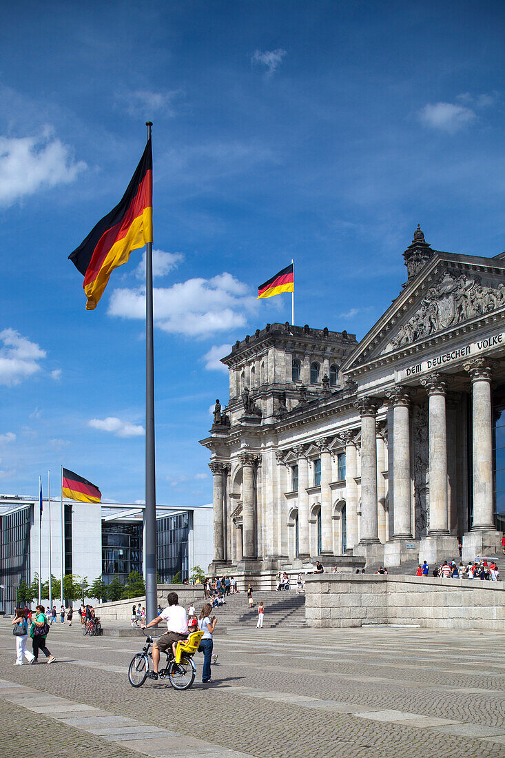 Berlin,Deutschland,29. Juli 2009,Menschen versammeln sich in der Nähe des ikonischen Reichstagsgebäudes in Berlin,um die beeindruckende Architektur und die bunten deutschen Fahnen zu bewundern.