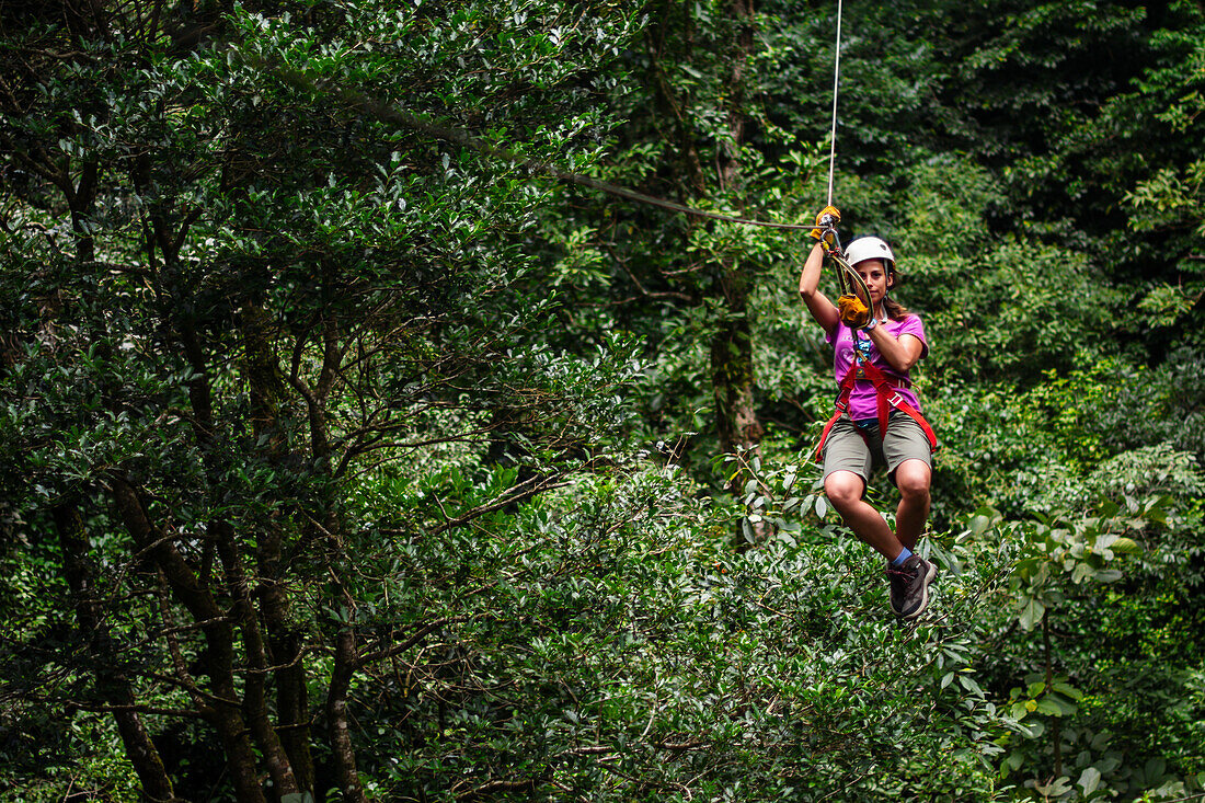 Junge kaukasische Frau hat Spaß bei einer Canopy-Tour in Costa Rica