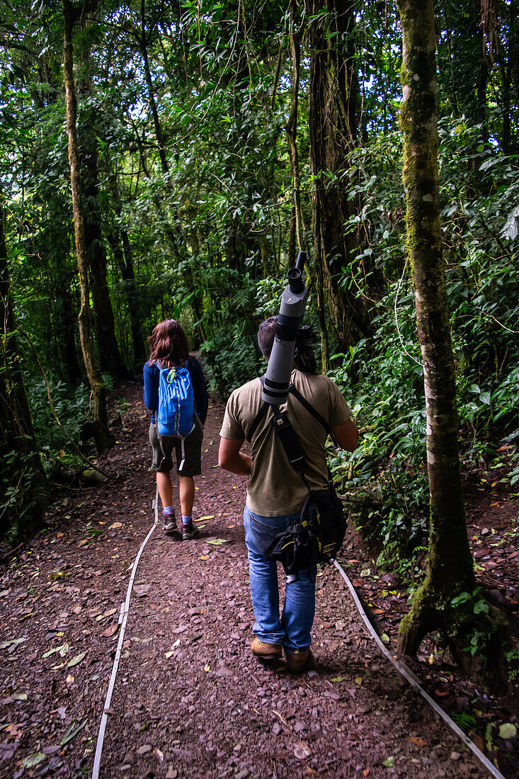 George of the Cloud Forest, guide and specialist, guides a young woman through Monterey cloud forest during fauna tour, Costa Rica