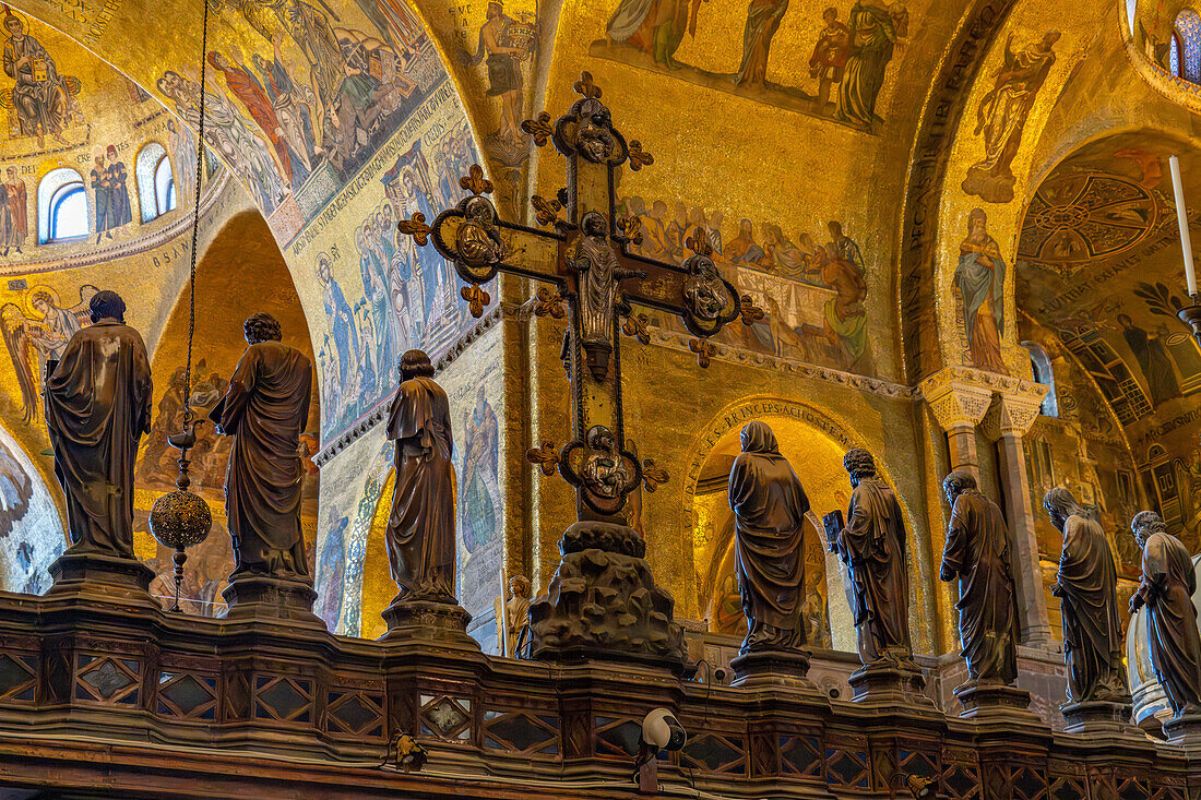 Das silberne und bronzene Kruzifix auf dem gotischen Altarschirm des Markusdoms in Venedig,Italien. Auf beiden Seiten stehen Statuen der Jungfrau Maria und der zwölf Apostel.