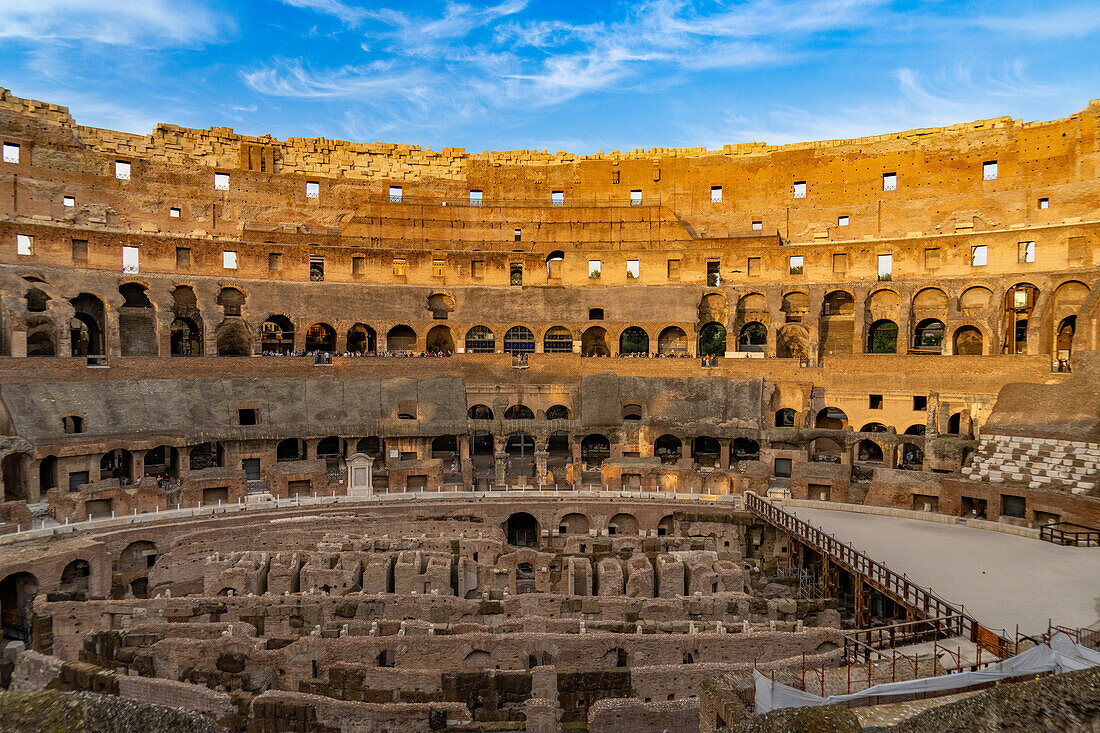 Interior of the Roman Colosseum or Flavian Amphitheater with golden sunset light in Rome, Italy. The tunnels under the floor of the arena were called hypogeum.