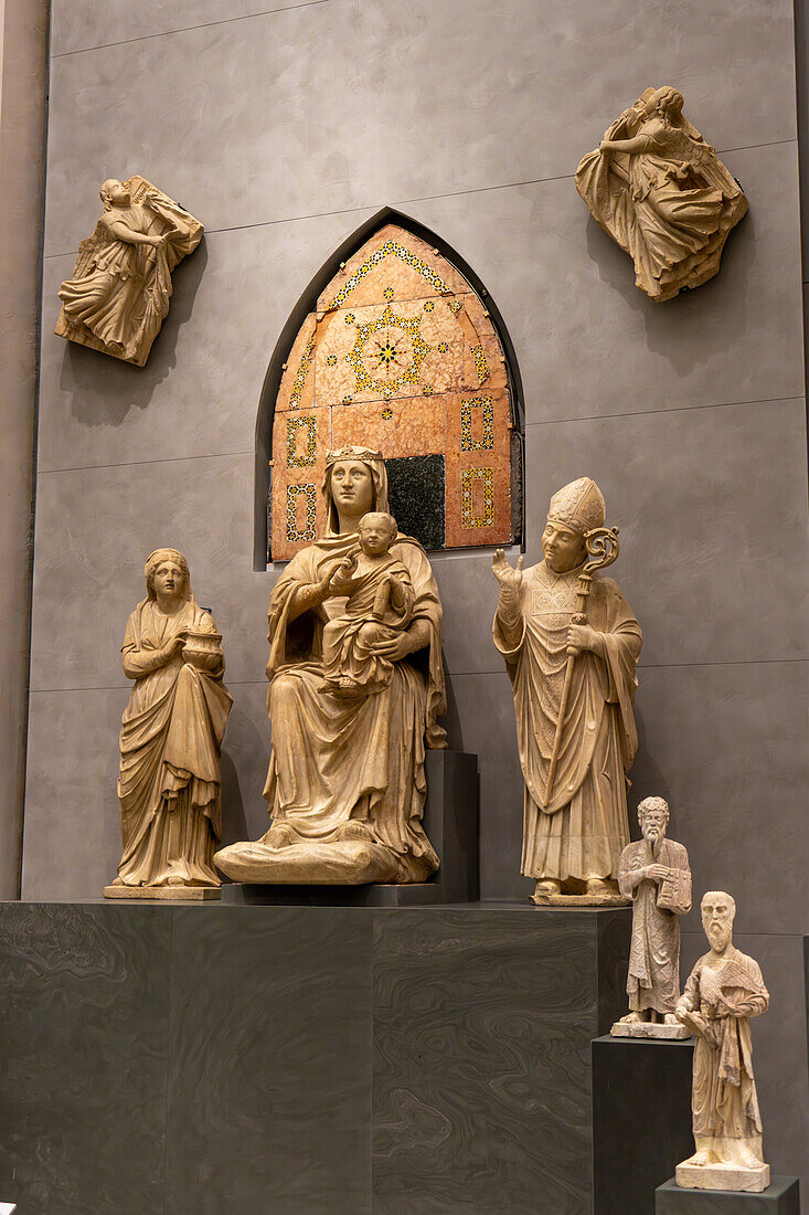 Sculptures by Arnolfo di Cambio in the Duomo in the Duomo Museum in Florence, Italy. L-R: Santa Reparata, Mary in Majesty, & Saint Zanobi. Behind is the Backrest of Mary's Throne and two Angels Lifting Curtains.