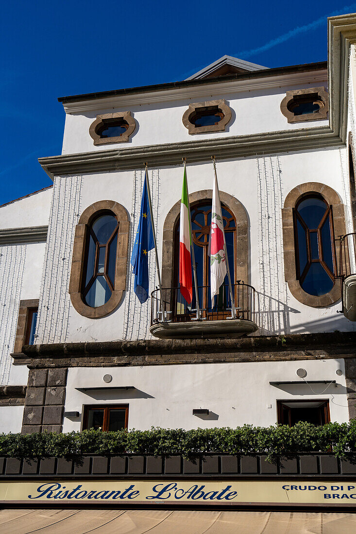 Flags on the front of a restaurant on the Piazza Sant'Antonino in the historic center of Sorrento, Italy.