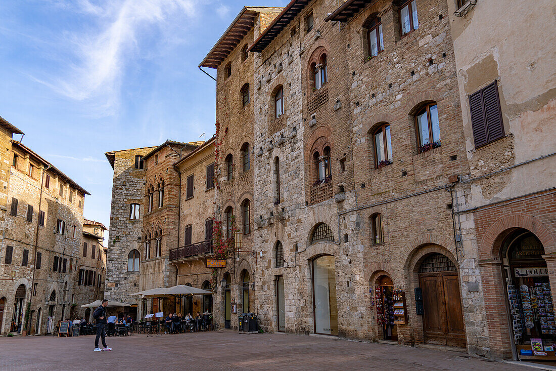 Mittelalterliche Gebäude rund um die Piazza della Cisterna in der ummauerten Stadt San Gimignano, Italien.