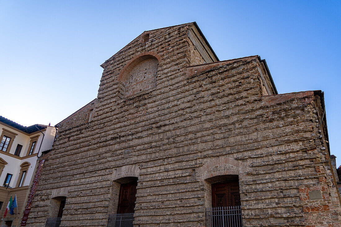 Schlichte Fassade der mittelalterlichen Basilica di San Lorenzo in Florenz, Italien. Mittelalterliche Kirchen in Italien hatten zu dieser Zeit typischerweise sehr schlichte Fassaden.