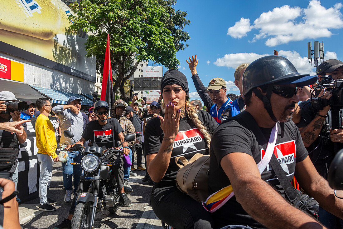 Der Regierung von Nicolas Maduro nahestehende Motorradfahrer der Gruppe Tumaparo fahren an einer Kundgebung der Opposition vorbei.