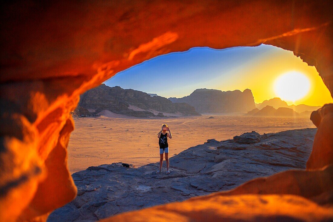 Touristenmädchen fotografiert bei Sonnenuntergang über dem roten Sand der Wüste von Wadi Rum, Jordanien