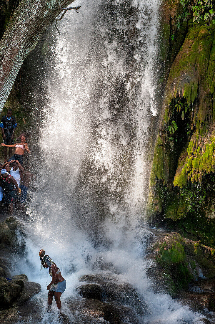 Haiti Voodoo Festival in Saut d'Eau, in Saut d'Eau, Ville Bonheur, Haiti. Tausende von Vodou- und katholischen Anhängern versammelten sich unter dem Wasserfall von Saut d'Eau in Haiti. Die Wallfahrt, die sowohl von Voodou-Anhängern als auch von Katholiken unternommen wird, hat ihren Ursprung in der Sichtung des Bildes der Jungfrau Maria auf einem Palmblatt in der Nähe des Wasserfalls vor einem halben Jahrhundert. Der Katholizismus und die Voodou-Praktiken sind in ihrer haitianischen Form für immer miteinander verwoben. Das Erscheinen eines Regenbogens unter den Wasserfällen soll bedeuten, dass