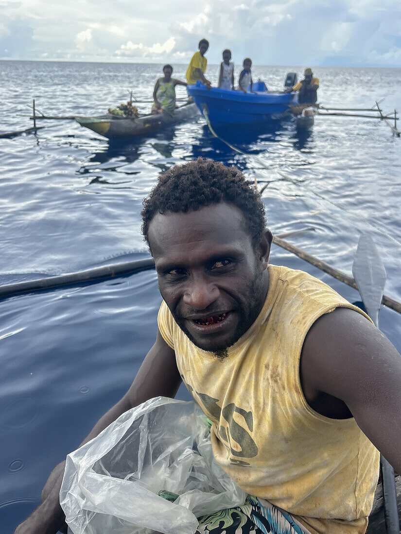 Residents of New Hanover island in their traditional dugout canoes, New Ireland province, Papua New Guinea