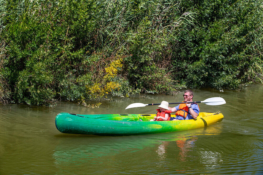 Kajakfahren auf dem Canal du Midi in Trèbes, Frankreich. Boot im Canal du Midi in der Nähe von Carcassonne Aude Südfrankreich Südliche Wasserstraße Wasserstraßen Urlauber stehen Schlange für eine Bootsfahrt auf dem Fluss, Frankreich, Europa