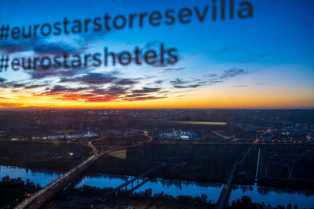 Admire the vibrant sunset over Seville seen from Torre Sevilla, with hashtags reflecting the city's charm and skyline.