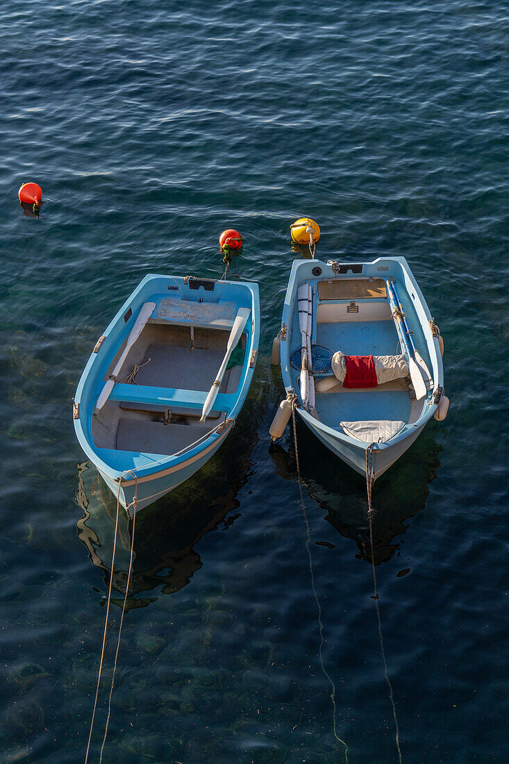 Zwei kleine Ruderboote liegen im Hafen von Riomaggiore, Cinque Terre, Italien.