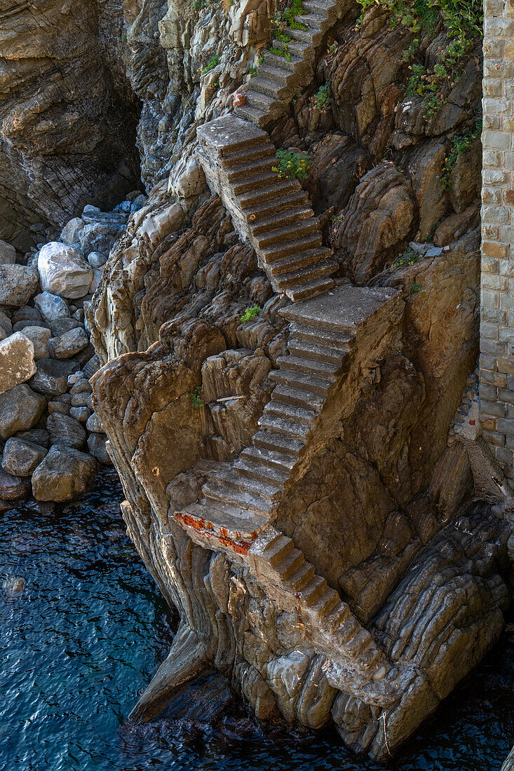 Steile Treppe hinunter zu einem Anlegeseil am Wasser des Lingurischen Meeres bei Riomaggiore, Cinque Terre, Italien.